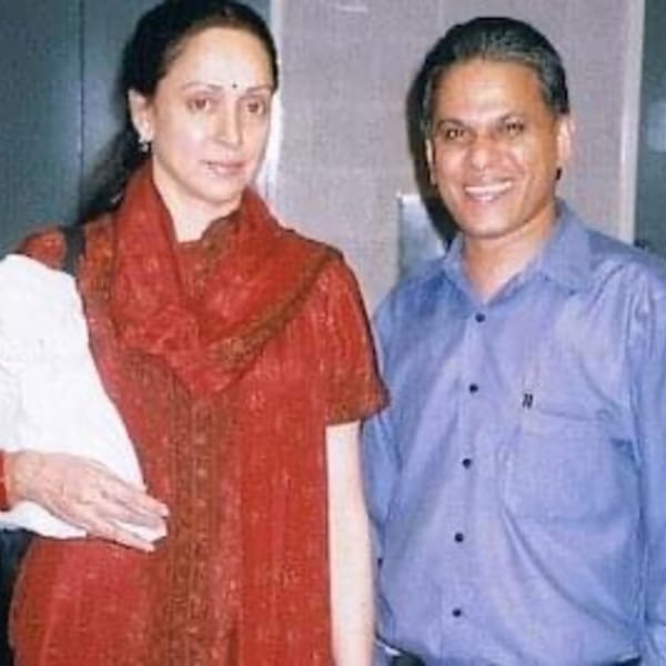 A woman in a red top and a man in a blue shirt smiling at the camera.